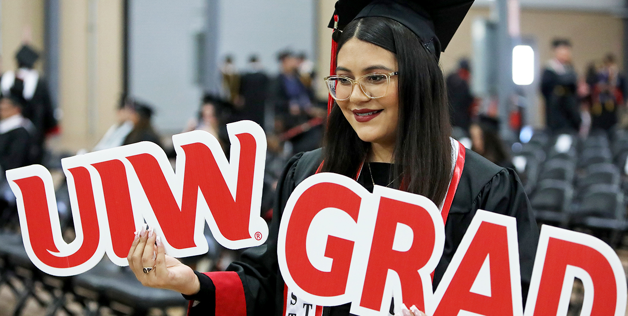 Student holding UIW Graduate sign