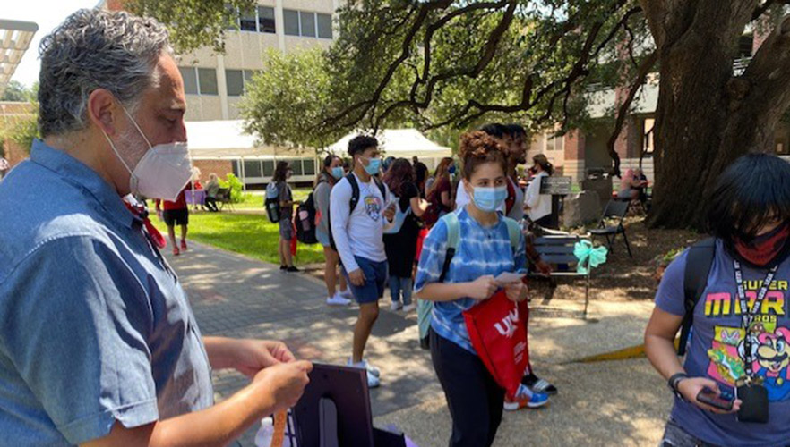 Students at a hand out table in the UIW quad