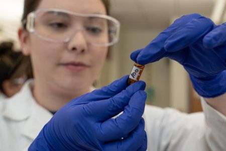 student observing small vial