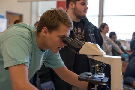 student looking through microscope