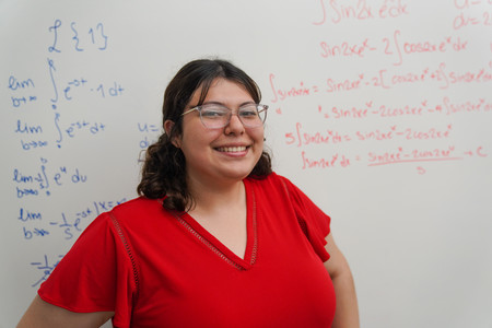 students standing in front of a whiteboard with equations