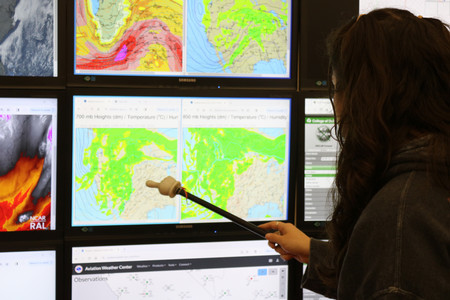 student pointing at weather display