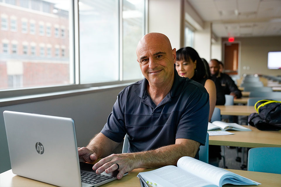 man sitting at desk working on computer