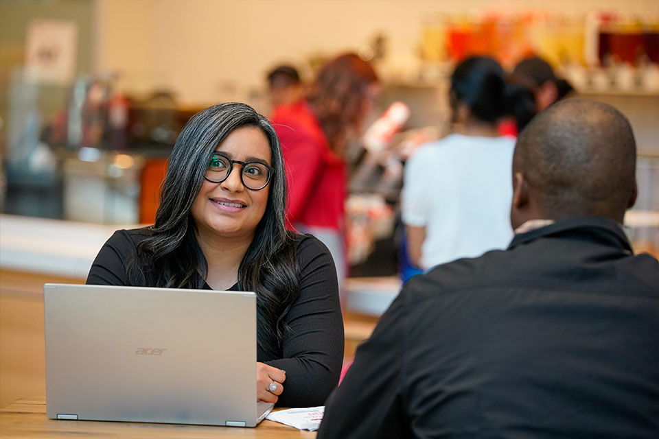 Two students sitting at table having conversation
