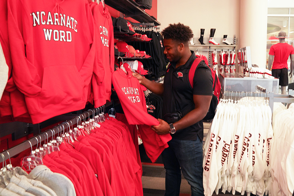 man shopping for UIW clothing at bookstore