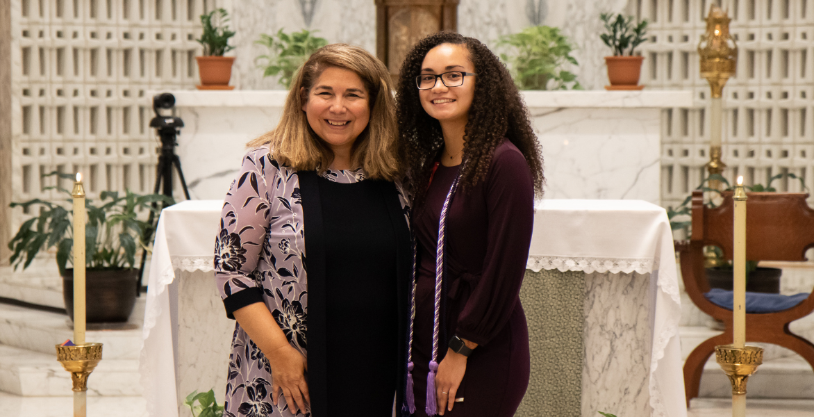 Dr. Yvonne Davila pinning a graduate in a purple dress