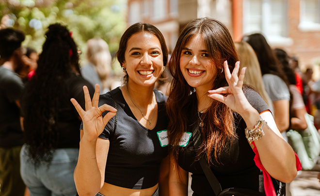 Four students walking and smiling