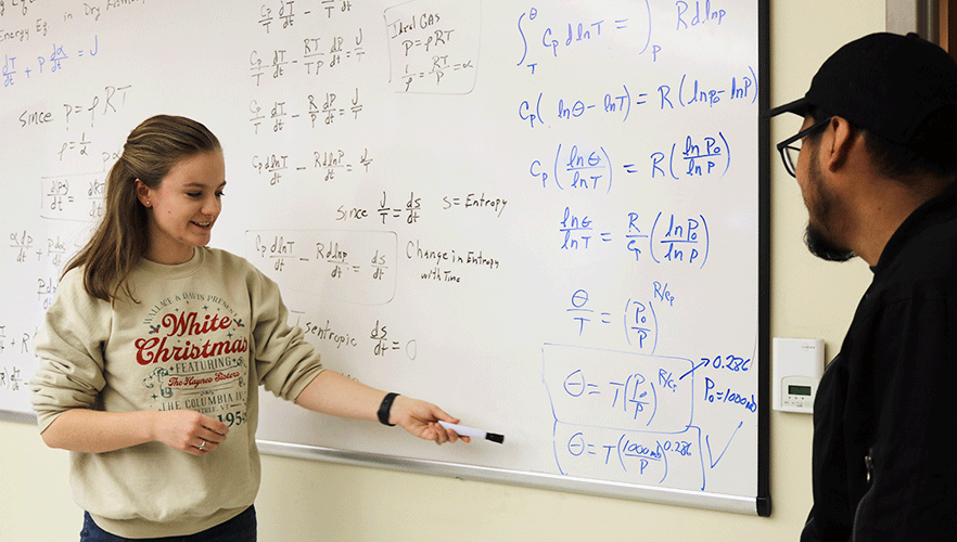 2 meteorology students working math equations
