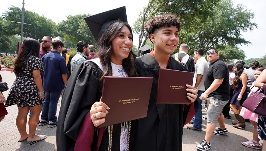 Two graduates with dipoloma