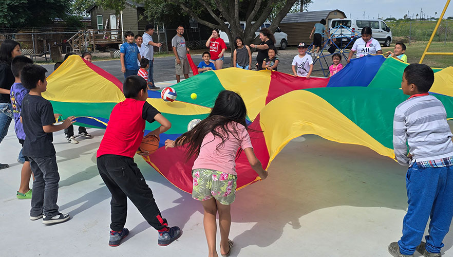 ARISE children playing on playground with UIW student
