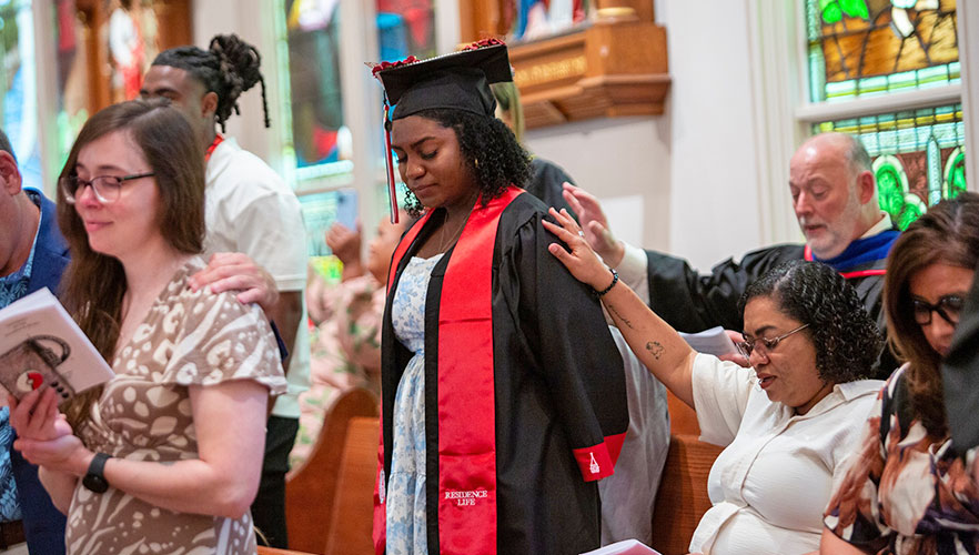 Parent praying over gradating student