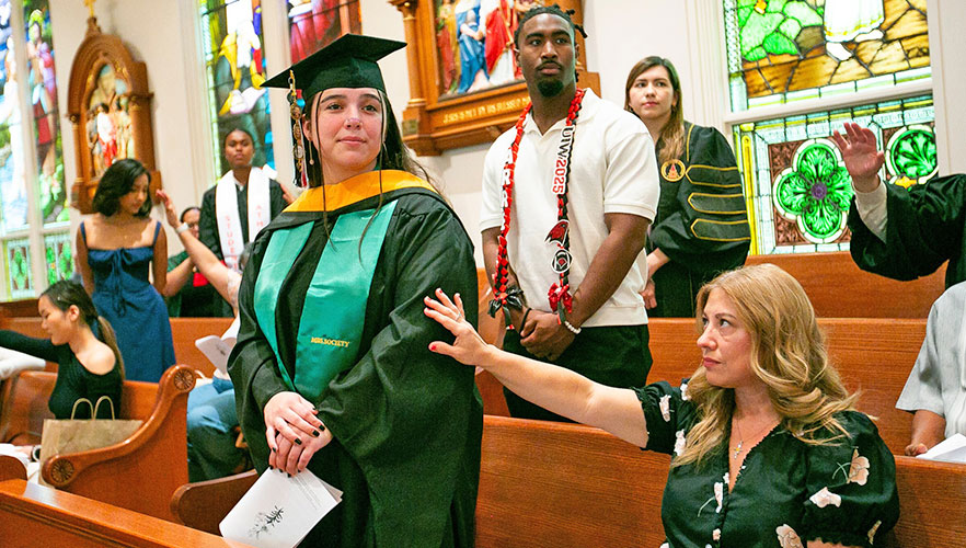 Parent praying over gradating student