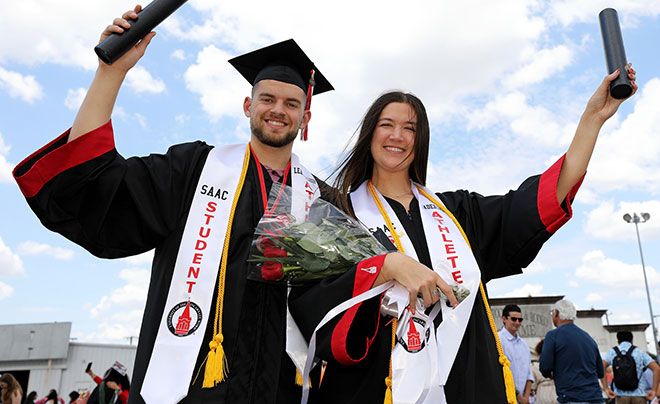 Spring 2025 graduates smiling with degrees