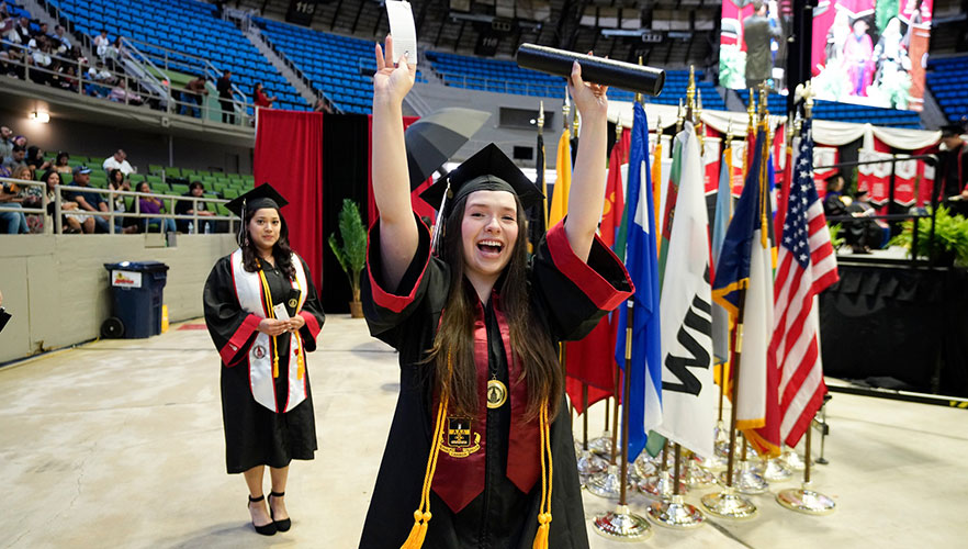 Graduate cheering with degree