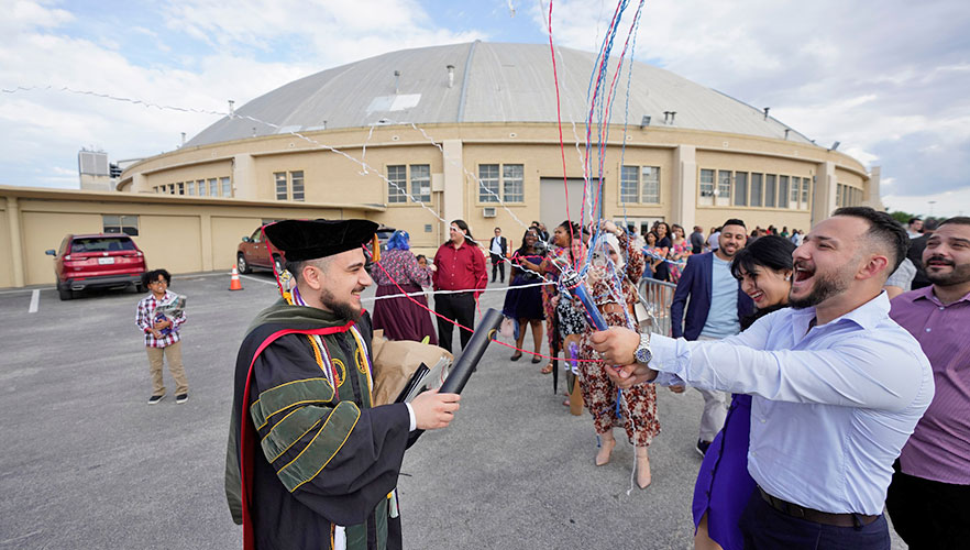 Graduate's family popping confetti in celebration of graduate