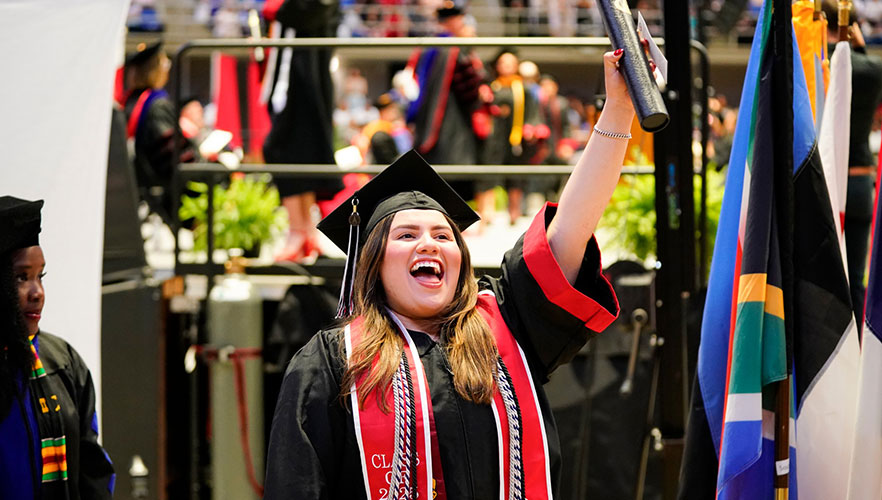 Graduate cheering with degree in hand