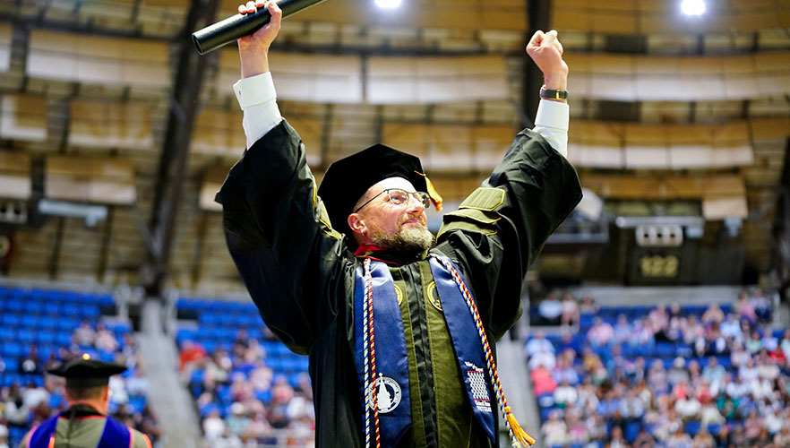 Graduate cheering with degree in hand