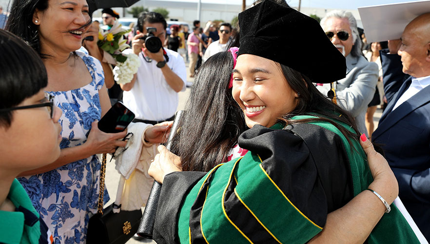 Graduate hugging family