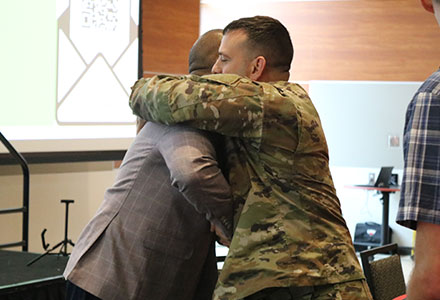 Chaplain Davis hugging symposium attendee