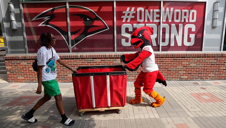 Red the Cardinal helping to move in students