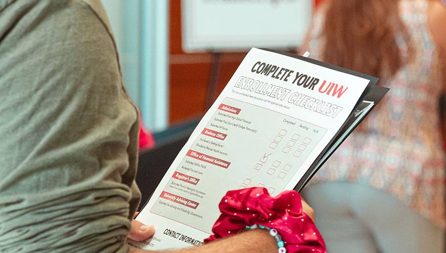 Attendees holding orientation paper work