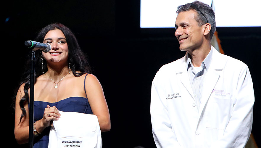 Student being handed white coat