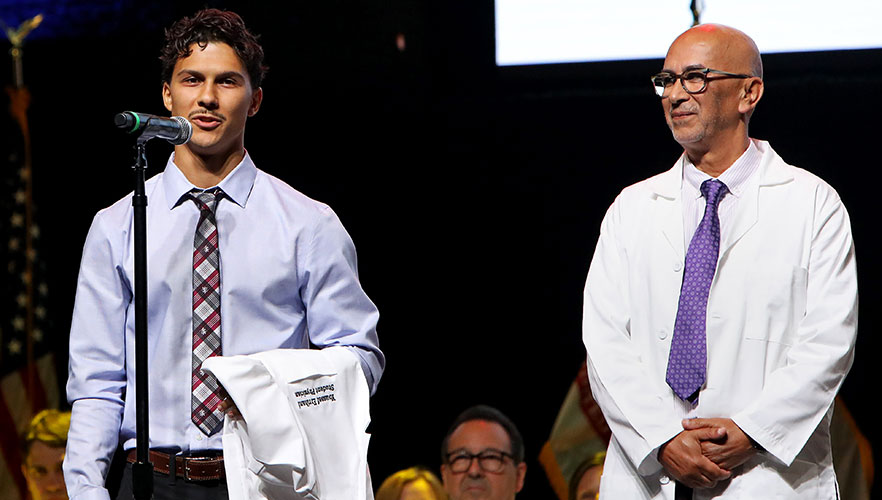 Student being handed white coat