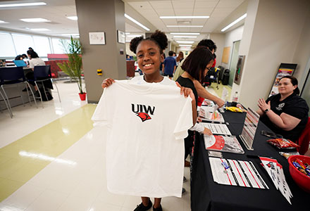 Student holding UIW shirt