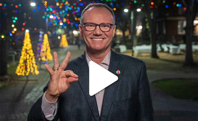 UIW president and Christmas lights with video play button