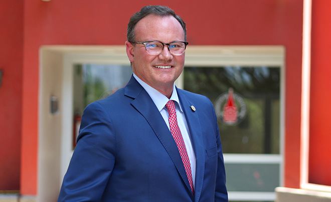 UIW President Evans against red wall