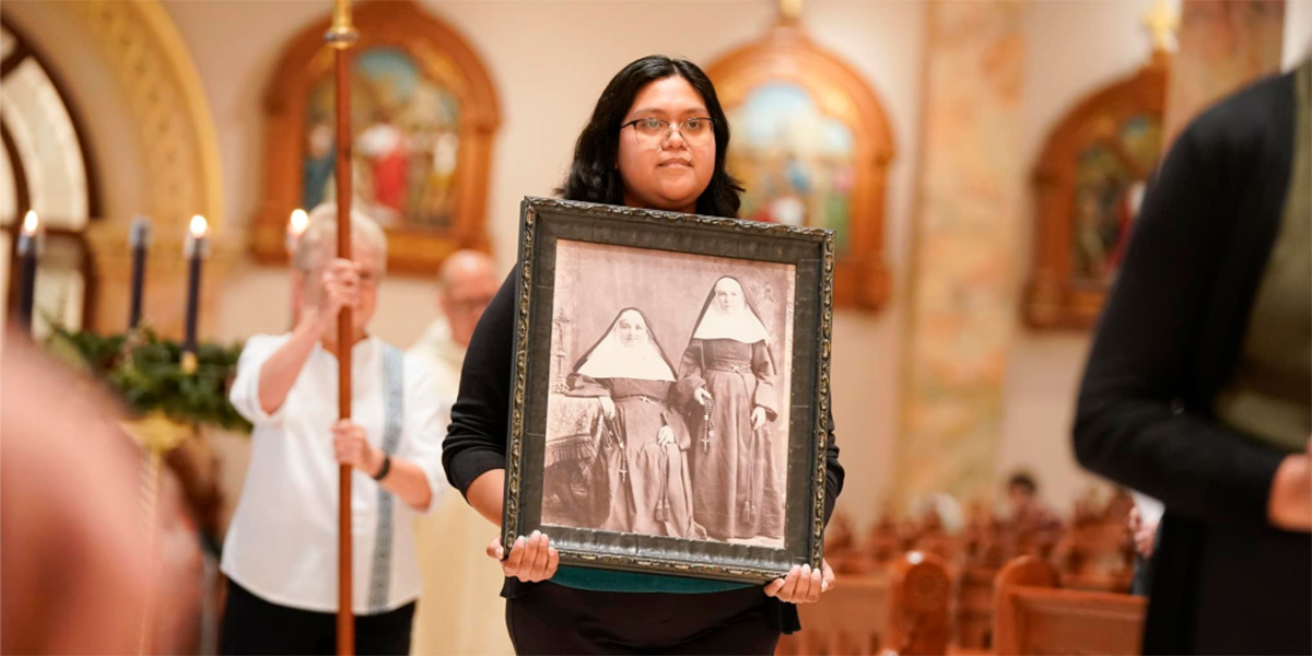 Student holding Sisters photo at Mass