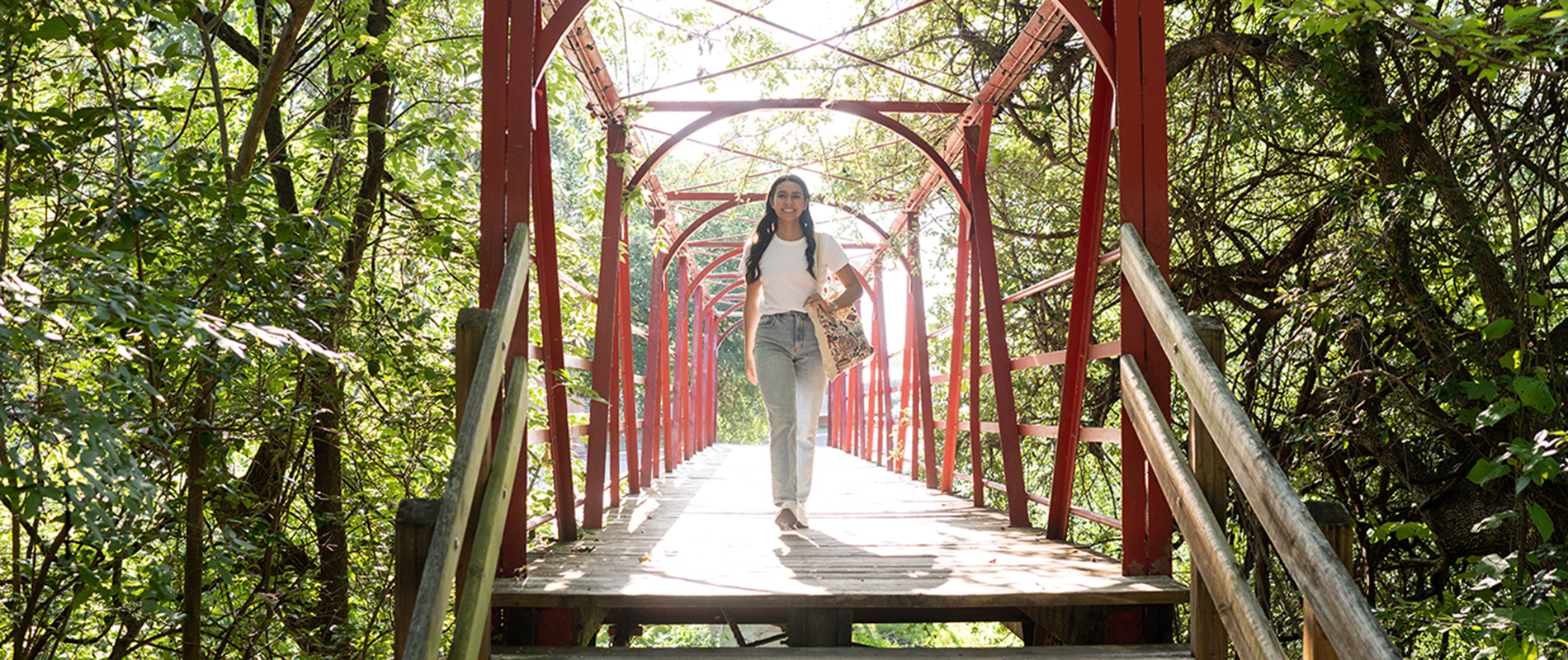 UIW student walking on campus bridge