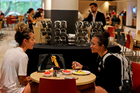 Two female students eating in the UIW cafeteria